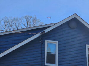 A drone flying over a home to take photos to create a digital rendering of the roof top.
