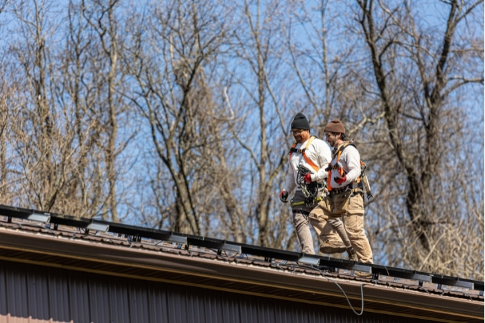 The Exact Solar team installing a solar panel on a roof