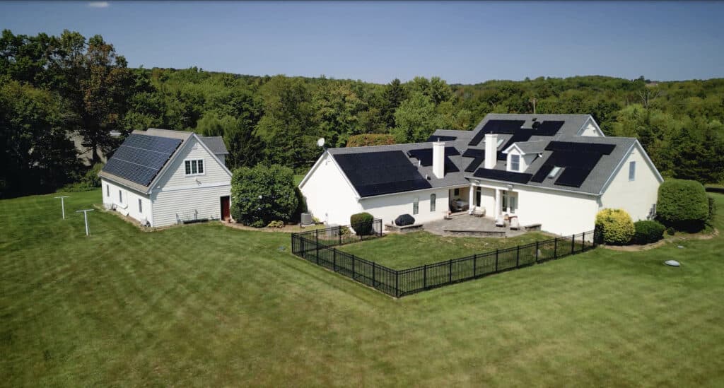 A home and detatched garage with rooftop solar panels.