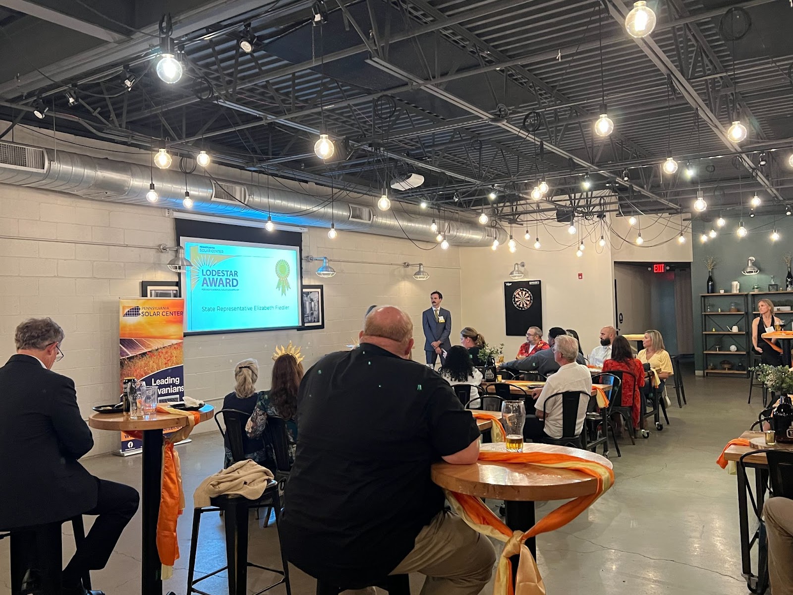 Lodestar Award attendees sitting at tables in a room with a projector screen