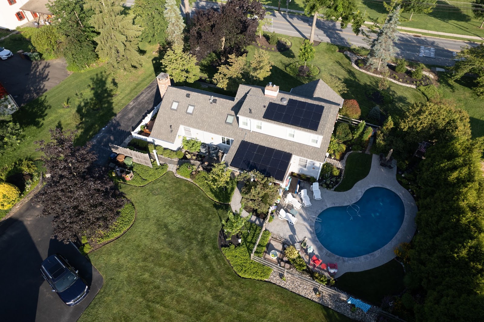 An aerial photo of a house with a pool and a rooftop solar system