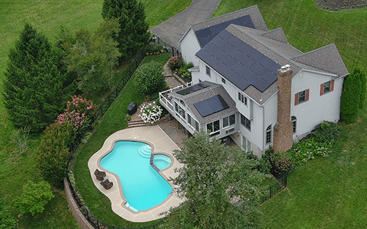 Home with a pool and solar panels on the roof